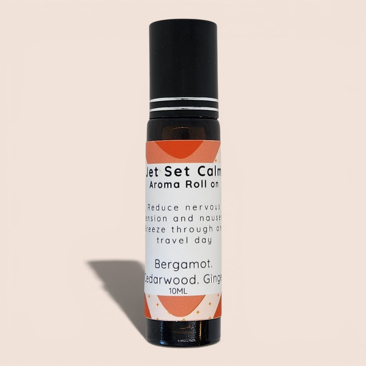 A 10ml Bergamot, Cedarwood, and Ginger aroma roll-on bottle with a black cap and a white label featuring orange graphic accents, set against a solid beige background.